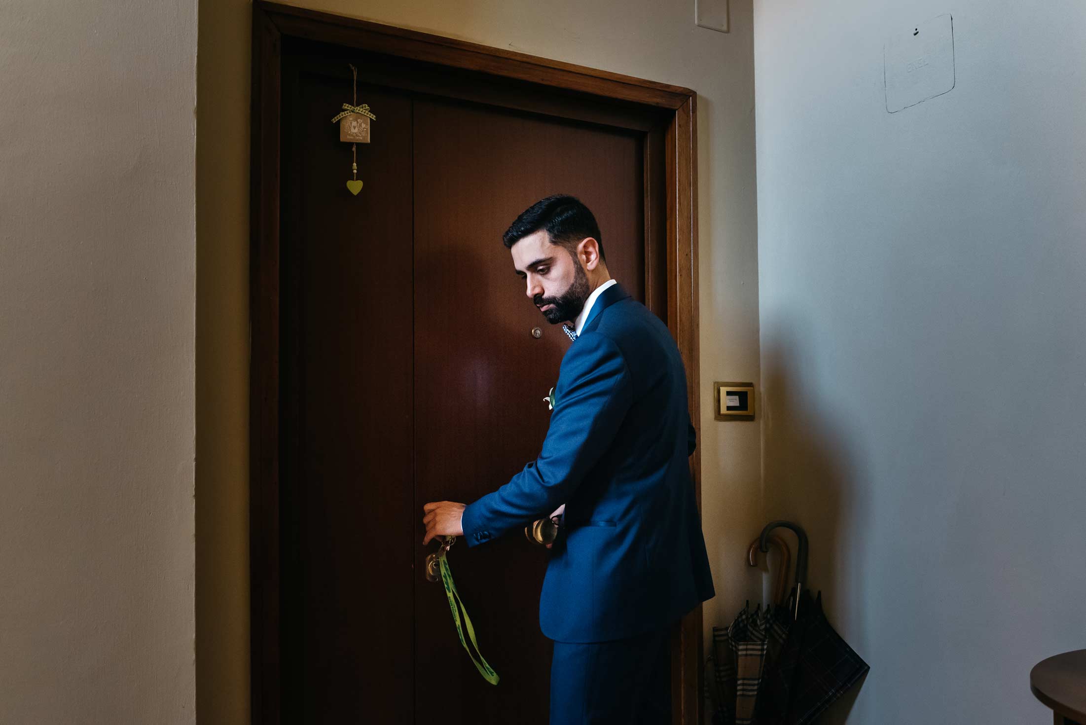 Groom exiting from home in documentary wedding photography style