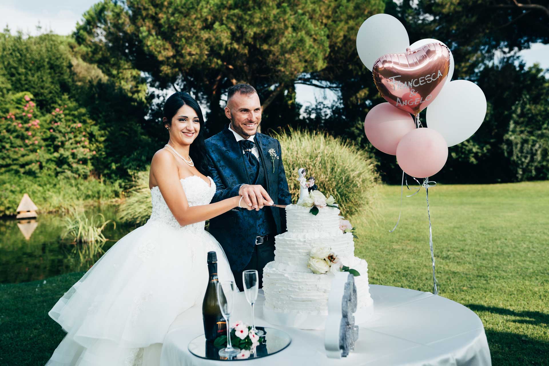 Taglio della torta, giardino di villa rosantica durante il matrimonio