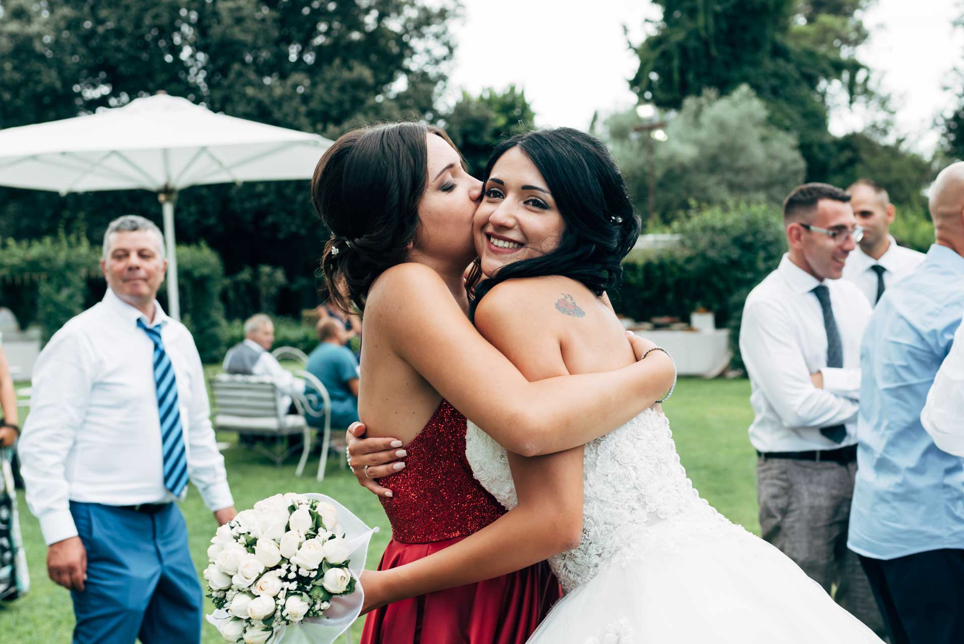 La sorella bacia la sposa durante un ricevimento di matrimonio a Villa Rosantica