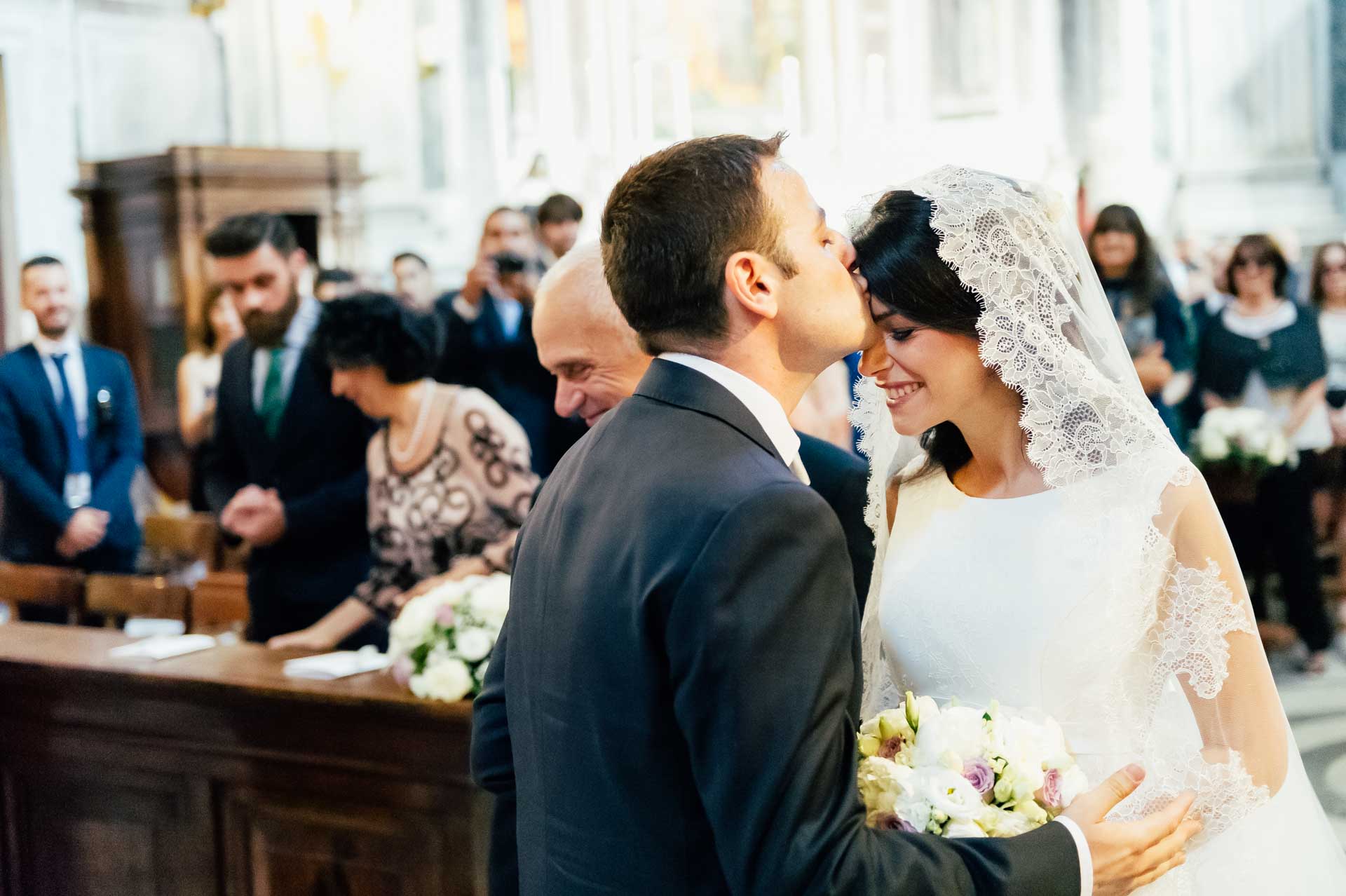 Bacio degli sposi all'entrata della chiesa di Santa Maria di Loreto a Roma durante un matrimonio