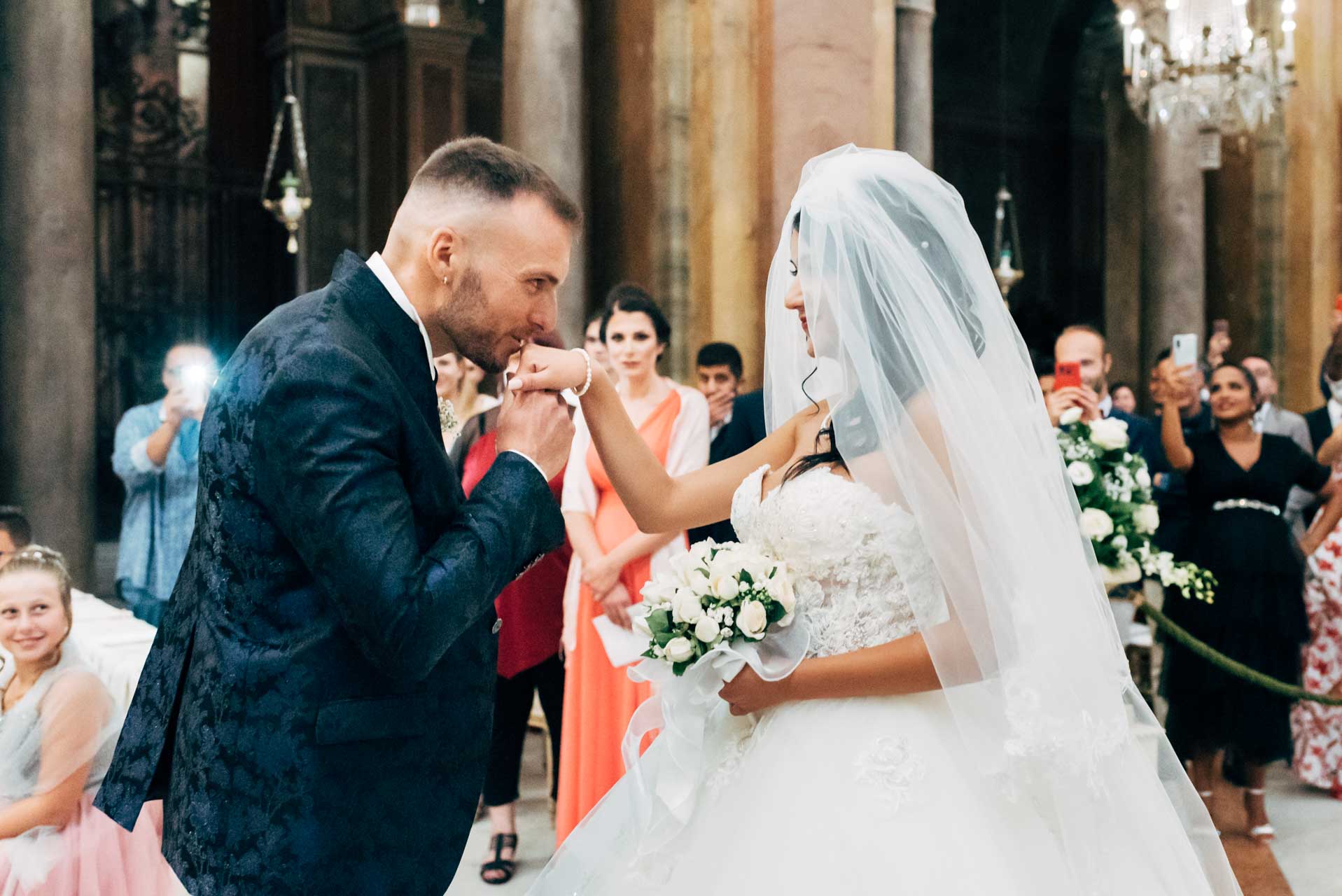 Lo sposo bacia la sposa all'arrivo nella basilica di ss Giovanni e Paolo, la chiesa dei lampadari